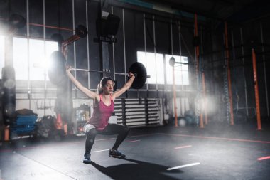 Spor salonunda bir halter ile atletik kız inşaat dışarı