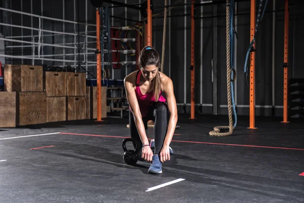 Αθλητικό κορίτσι έτοιμοι να αρχίσετε ασκήσεις με ένα kettlebell στο γυμναστήριο — Φωτογραφία Αρχείου