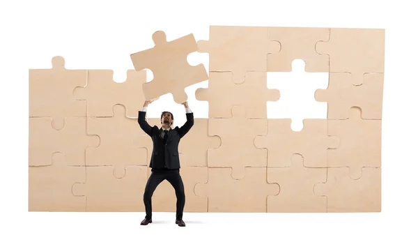 Homem de negócios com uma peça de puzzle. Construir o conceito de negócio — Fotografia de Stock