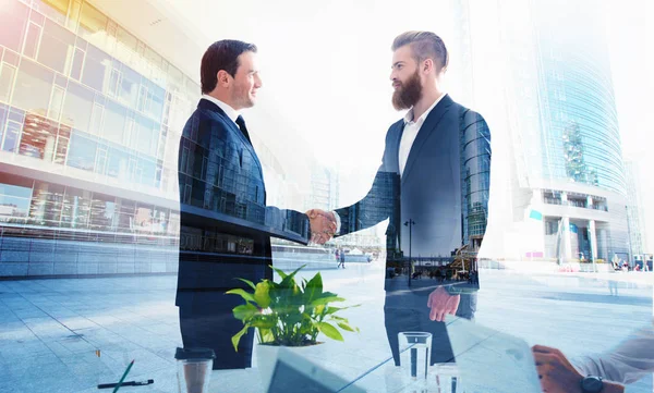 A apertar as mãos de um empresário no escritório. conceito de trabalho em equipe e parceria. Dupla exposição — Fotografia de Stock