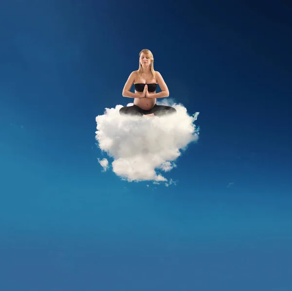 Pregnant woman doing yoga on a cloud — Stock Photo, Image