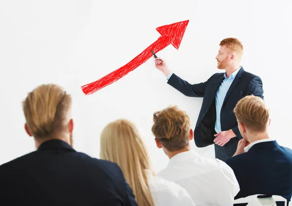 Geschäftsmann zieht bei einem Schulungstreffen positive Zahlen über sein Unternehmen. Erfolgskonzept — Stockfoto