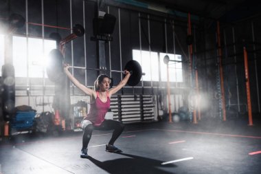 Spor salonunda bir halter ile atletik kız inşaat dışarı
