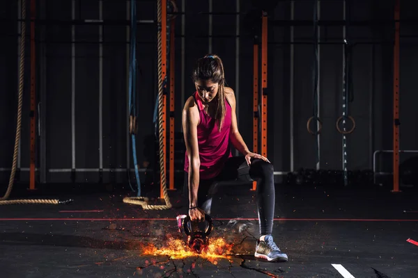 Sportos lány összejön az edzőteremben, a tüzes kettlebell — Stock Fotó