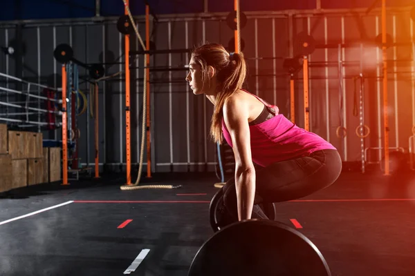 Atletica ragazza si allena in palestra con un bilanciere — Foto Stock