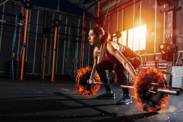 Atletica ragazza si allena in palestra con un ardente bilanciere — Foto Stock