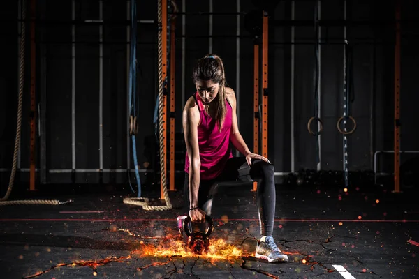 Atletische meisje werkt op de sportschool met een vurige kettlebell — Stockfoto