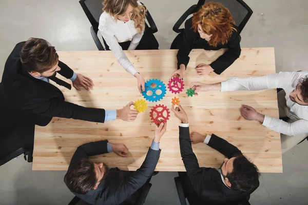 Бізнес команда з'єднує шматочки шестерень. Концепція командної роботи, партнерства та інтеграції — стокове фото