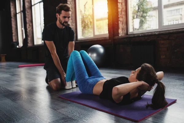 Personal trainer helps a girl with the gym exercises — Stock Photo, Image