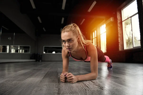 Blond flicka tränar på gym — Stockfoto