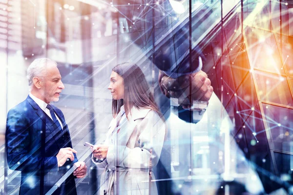 Un apretón de manos en la oficina. concepto de trabajo en equipo y asociación. Doble exposición —  Fotos de Stock