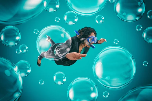 Woman swimming among air bubbles with mask and snorkel in a deep turquoise background — Stock Photo, Image