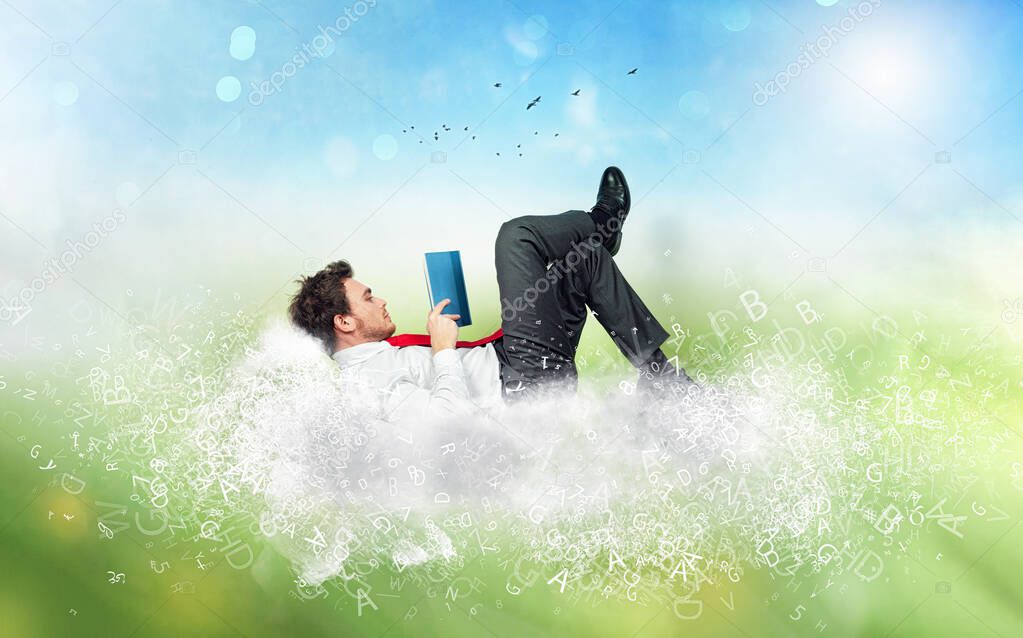 Businessman reads a book over a cloud made of letters. Concept of relax and imagination