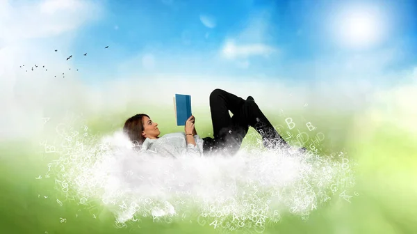 Affärskvinna läser en bok över ett moln av bokstäver. Begreppet avslappning och fantasi. — Stockfoto