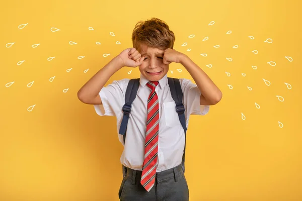 A criança chora porque não quer ir à escola. Fundo amarelo — Fotografia de Stock