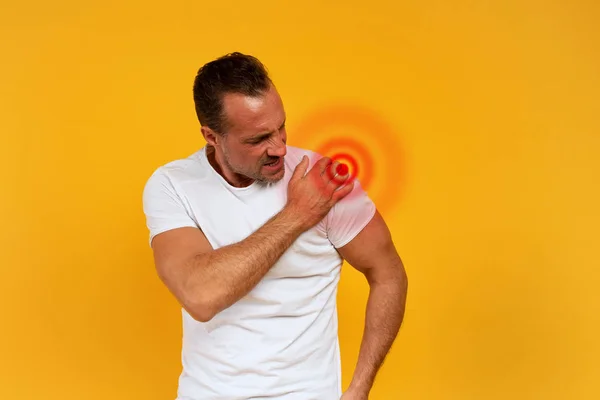 Homem com dores nas costas. Fundo amarelo — Fotografia de Stock