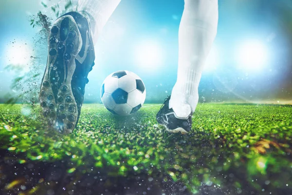 Футбольная сцена в ночном матче с крупным планом футбольной обуви, ударяющей по мячу — стоковое фото