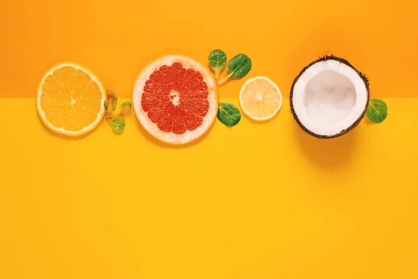 Skład owoców cytrusowych, pomarańczy, cytryny i kokosów na żółtym tle — Zdjęcie stockowe