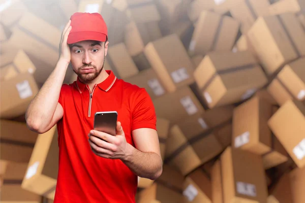 Kurier ist verwirrt aufgrund der vielen Pakete, die ausgeliefert werden müssen. Konzept der Überlastung und Internet-Ordnung — Stockfoto