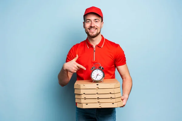 Entregador é pontual para entregar rapidamente pizzas. Contexto ciano — Fotografia de Stock