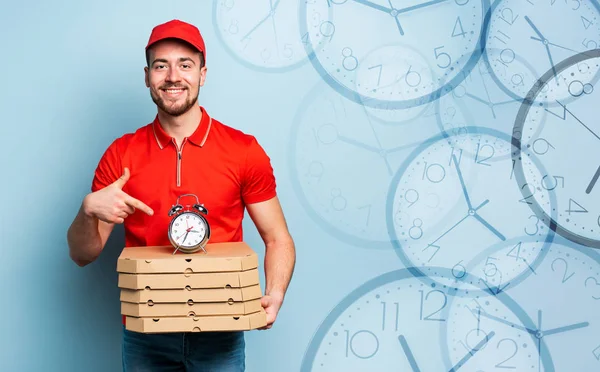 Entregador é pontual para entregar rapidamente pizzas. Contexto ciano — Fotografia de Stock