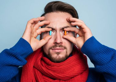 Çocuk üşütmüş ve iyileşmek için hap kullanıyor. Cyan arkaplan stüdyoları