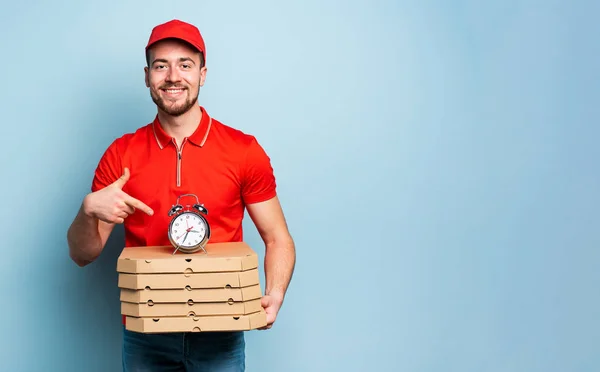 Entregador é pontual para entregar rapidamente pizzas. Contexto ciano — Fotografia de Stock