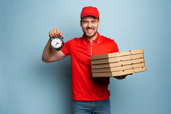 Entregador é pontual para entregar rapidamente pizzas. Contexto ciano — Fotografia de Stock