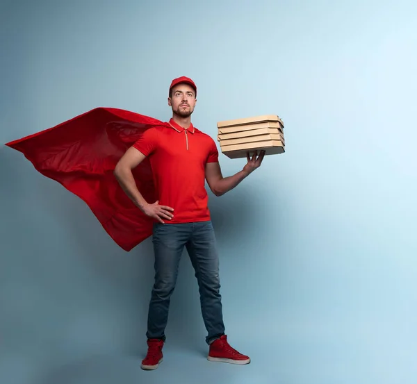 Deliveryman con pizzas actúa como un poderoso superhéroe. Concepto de éxito y garantía en el envío. Estudio de fondo cyan — Foto de Stock