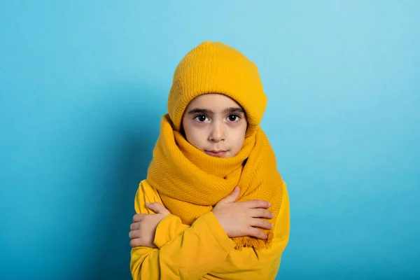 Çocuk üşütmemek için kendini kapatıyor. Cyan arkaplanı — Stok fotoğraf