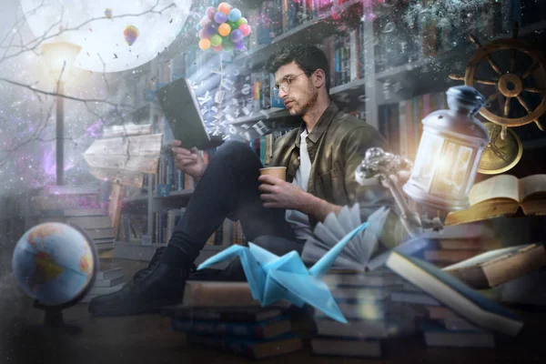O rapaz lê um livro à noite numa biblioteca. Conceito de fantasia, imaginação e criatividade — Fotografia de Stock
