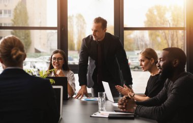 Ofiste birlikte çalışan iş adamları. Takım çalışması ve ortaklık kavramı