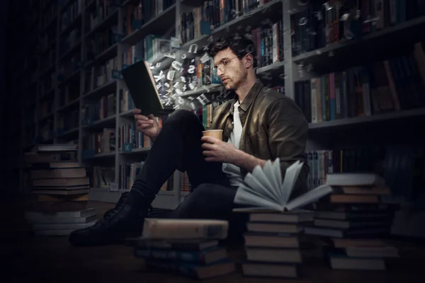 Boy reads a book in a library. Concept of curiosity, imagination and culture — Stok fotoğraf