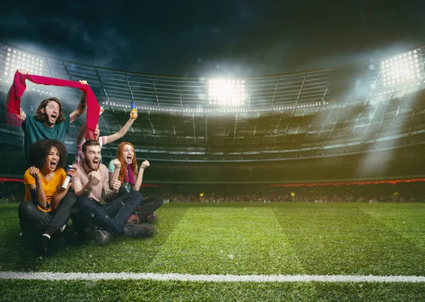 Voetbalfans in het midden van de actie tijdens een nachtwedstrijd in het stadion — Stockfoto