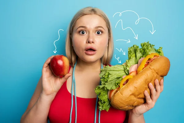 Tlustá holka dělá tělocvičnu a chce jíst sendvič. Pojem nerozhodnost a pochybnosti — Stock fotografie