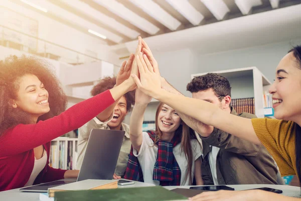 Die Schüler legen ihre Hände zusammen. Konzept der Teamarbeit und Partnerschaft — Stockfoto