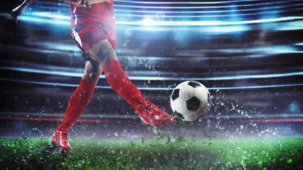 Piłka nożna w nocy mecz z graczem w czerwonym mundurze kopanie piłkę z mocą — Zdjęcie stockowe