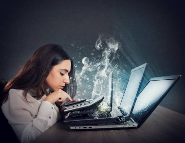 Businesswoman works with multiple devices, smartphone, calculator and laptops. Concept of overwork and stress