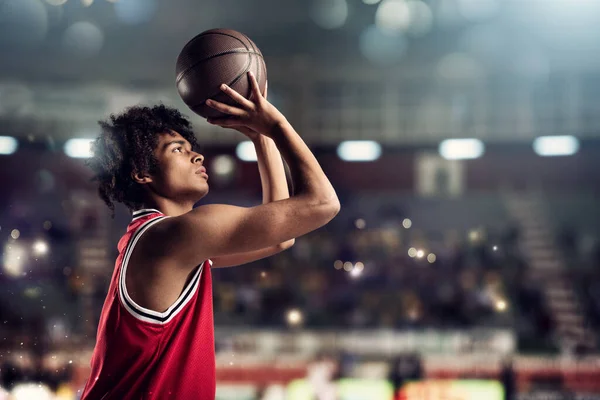 Basketspelare kastar bollen i korgen i arenan full av åskådare — Stockfoto