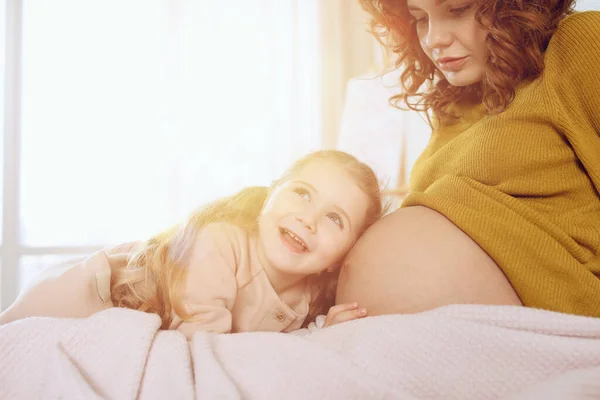 A mãe grávida brinca com a filha. Conceito de família, alegria e gravidez — Fotografia de Stock