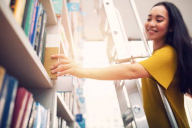 Kız okumak için bir kitap seçiyor. Kültür ve öğrenim kavramı