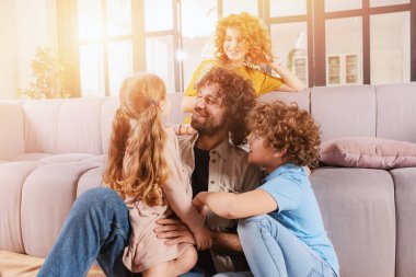 Mutlu aile kanepede birlikte oynuyor. Birleşme, aşk, şefkat kavramı