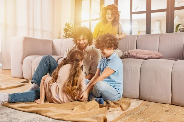 Família feliz jogar juntos em casa no sofá. conceito de união, amor, afeto — Fotografia de Stock