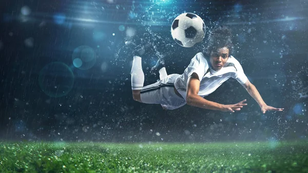 L'attaquant de football frappe le ballon avec un tir de tête acrobatique dans les airs au stade — Photo