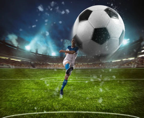 Scène de football lors d'un match de nuit avec un joueur en uniforme blanc et bleu donnant un coup de pied au ballon avec puissance — Photo