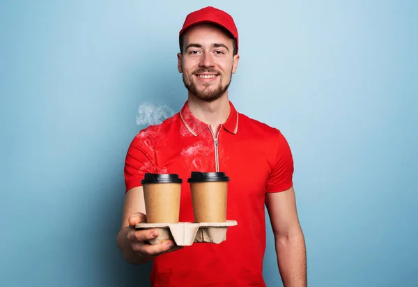 Courier is happy to deliver hot coffee. Cyan background — Stockfoto