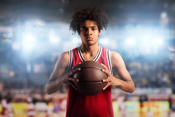 Pemain bola basket memegang bola di dalam keranjang di stadion yang penuh dengan penonton . — Stok Foto