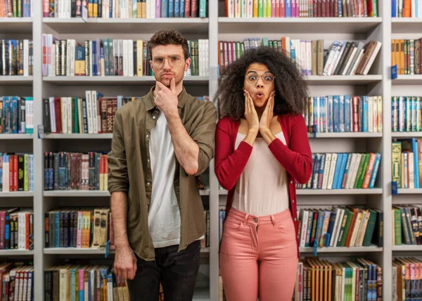 Young student with amazed expression in a library — Stok fotoğraf