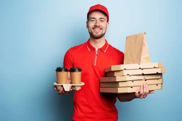 Kurier liefert gerne heißen Kaffee und Pizzen. Cyan-Hintergrund — Stockfoto