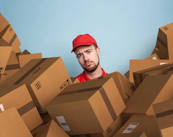 Courier is confused due to a lot of packages to deliver. concept of overwork and growth internet order. Cyan color background — Stock Photo, Image